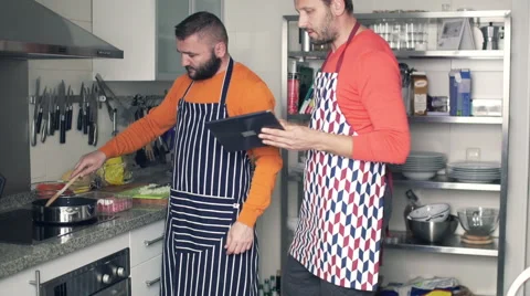 Young man using tablet during cooking in kitchen at home Stock Footage 58896879