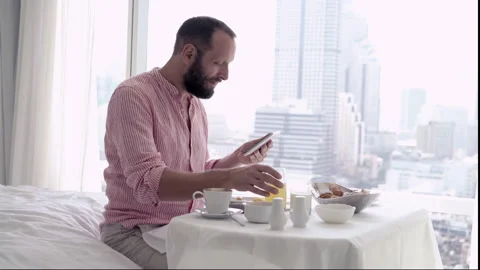 Young man using tablet during breakfast at home, 4K Stock Footage 88345463