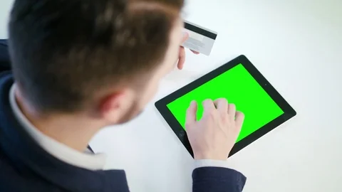 A Young Man Using a Tablet with a Green Screen Stock Footage 84768043