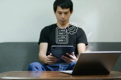 Young Man Using Tablet for Server Management at a Modern Office 写真素材