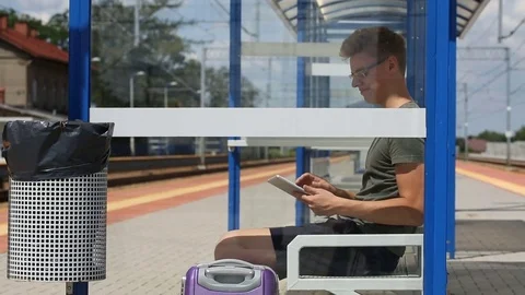 Young man using tablet on the train stop while waiting for the arrival Stock Footage 78655001