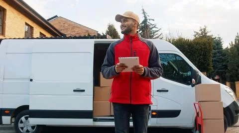 Young man using tablet to view information about the parcel. Delivering the Stock Photos