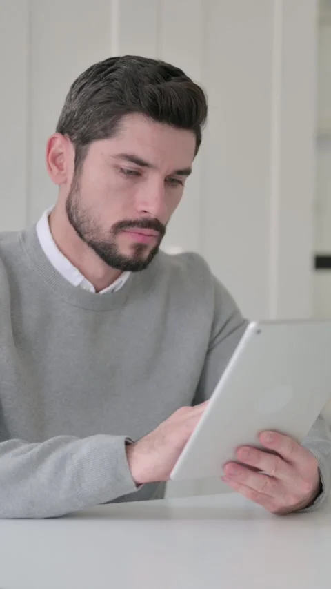 Young Man using Tablet while Sitting in Office, Vertical Video Stock Footage 339582151