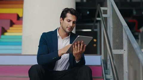 Young Man Using the Tablet for Working Purposes while Sitting Outside on the Stock-Footage 304175675