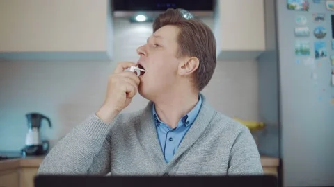 Young man using throat spray Stock Footage 148825185