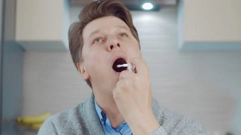 Young man using throat spray Stock Footage 148826043