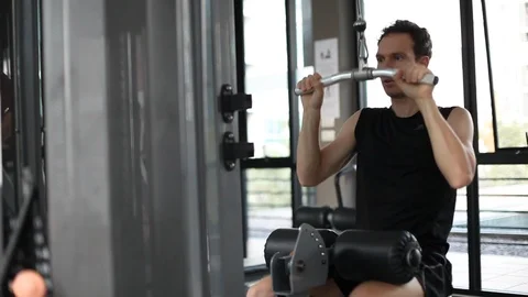 Young man using training apparatus in gym, muscle strength exercise Stock Footage 120186447
