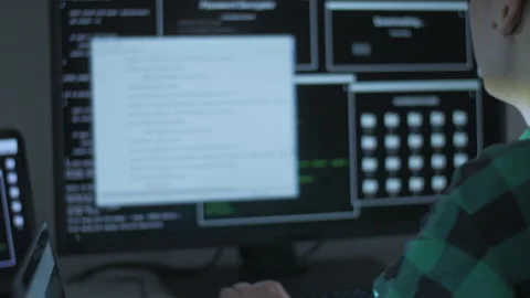 Young man using two computers for programming at home Stock Footage 142970696