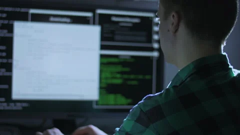 Young man using two computers for programming at home Stock Footage 142982997
