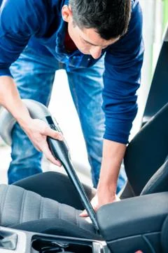 Young man using vacuum for cleaning the interior of a car Stock Photos