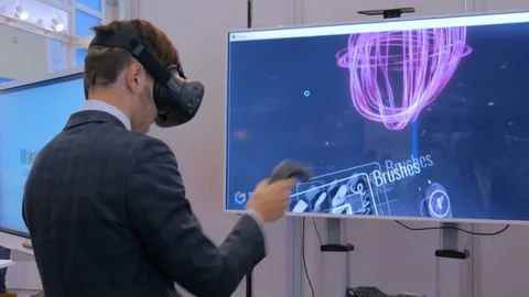Young man using virtual reality headset and drawing with special joystick Stock Footage