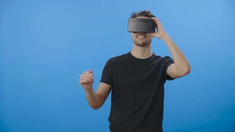 Young man using a virtual reality (VR) mask - 4K Stock Footage 88399455