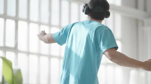 Young man using virtual reality glasses, playing video games, wearing new Stock Footage 272753975
