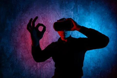 Young man using Virtual Reality glasses. Show ok Stock Photos