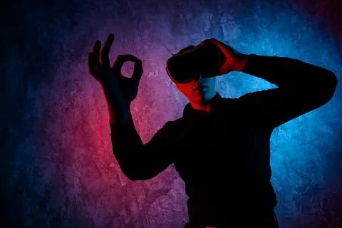 Young man using Virtual Reality glasses. Show ok Photos