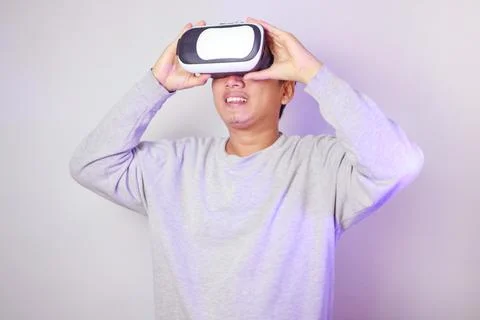 Young man using virtual reality headset, Isolated on gray background studio.. Stock Photos