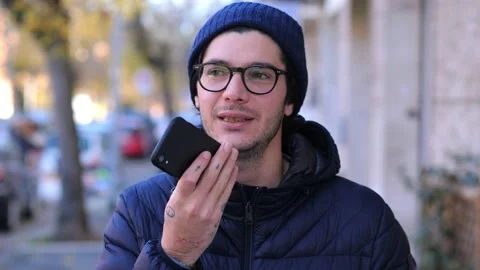 Young man using vocal assistant and sending vocal message outdoor Stock Footage 167363704