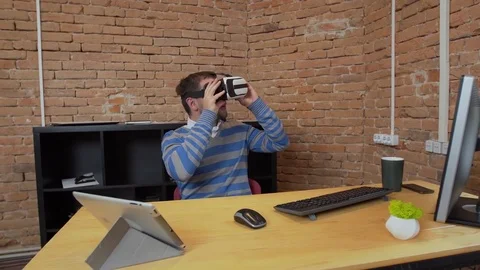 Young man using vr glasses for watching the video in the modern office. Stock Footage 82856244
