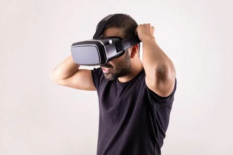 Young man using VR glasses headset, portrait on light background. Virtual Stock Photos