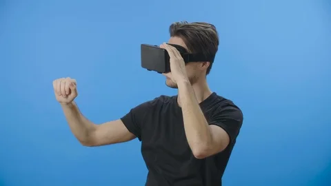 Young man using a VR mask and interacting with the virtual environment - 4K Stock Footage 88399441