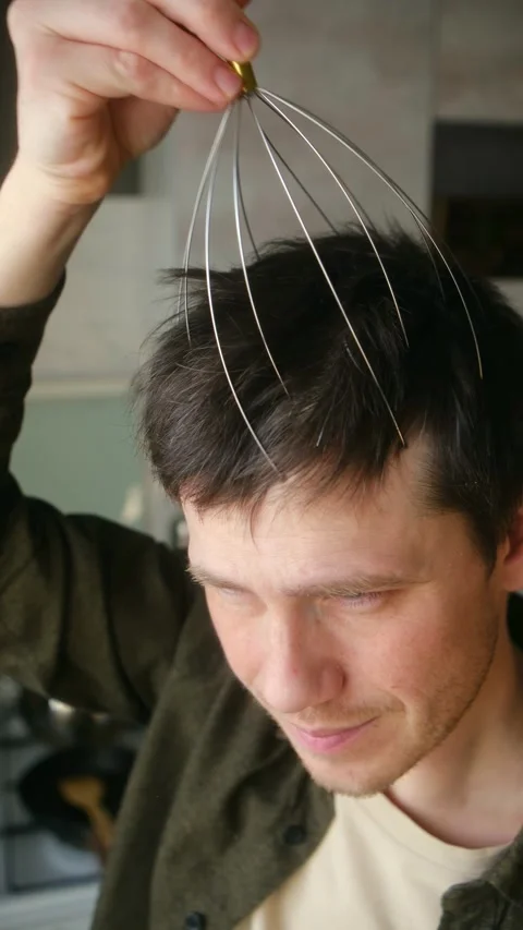 Young man using a wire head massager for relaxation Vídeo Stock 337828786