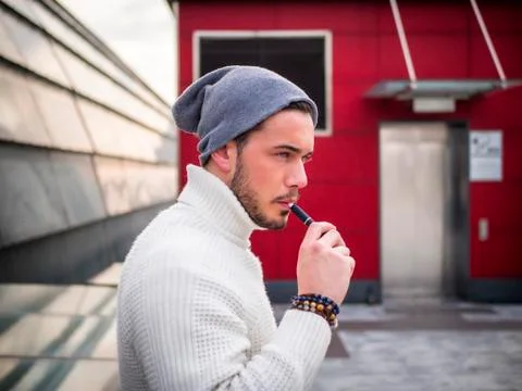 Young man vaping, smoking e-cigarette outdoor Stock Photos