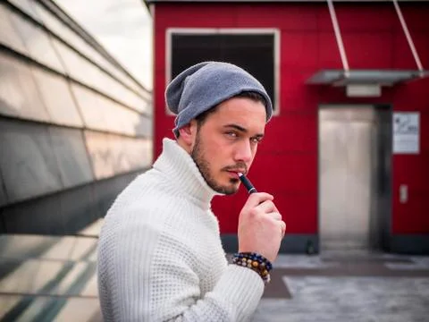 Young man vaping, smoking e-cigarette outdoor Stock Photos