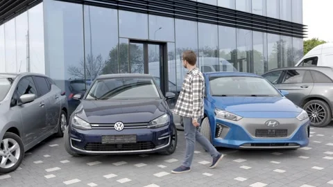 A young man is very impressive and happy, standing in front of his new car Stock Footage 303353862