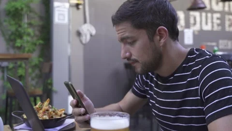 Young man in video call with mobile in bar outdoors Vídeo Stock 153107738