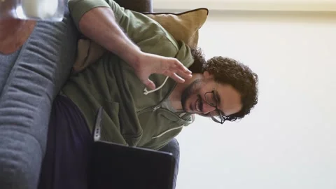 Young man in video call saying goodbye to laptop on the sofa Stock Footage 164906341