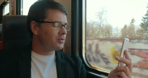 Young man video chatting on cell in train Stock Footage 52373534
