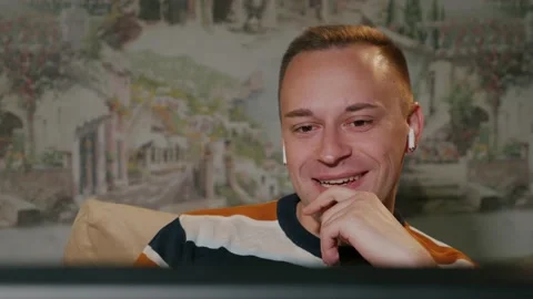 Young man video chatting using computer sit on sofa at home Stock Footage 130860110