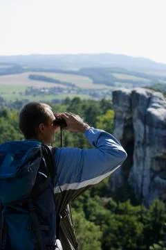 Young man viewing mountains with binoculars Stock Photos