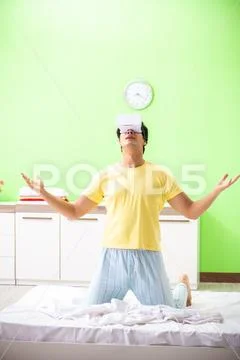 Young man with virtual glasses in the bedroom Stock Photos