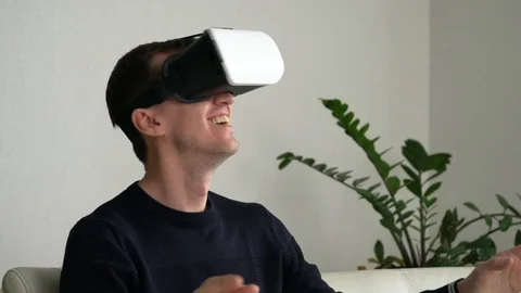 Young man in virtual reality glasses smiles and laughs close-up Video stock 108303567