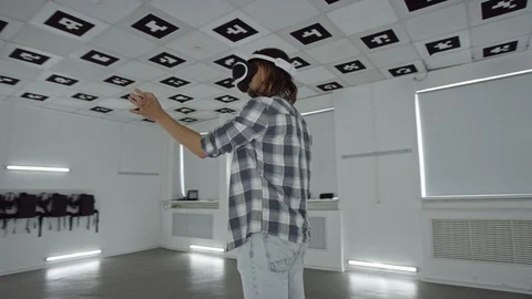 Young man in virtual reality headset making hand gestures in a videogame in an Stock Footage 124267533