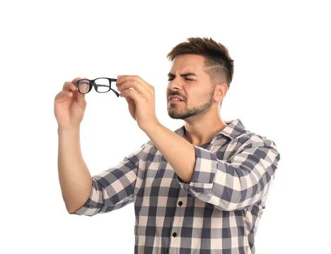 Young man with vision problems holding glasses on white background Stock Photos