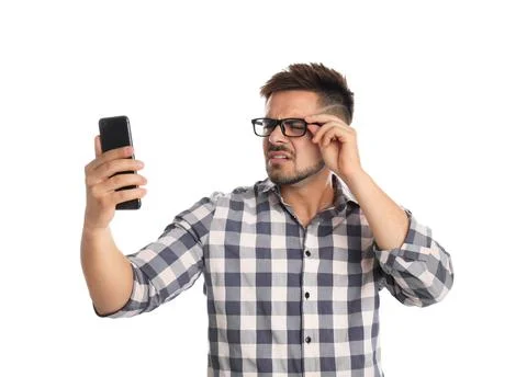 Young man with vision problems using smartphone on white background Stock Photos