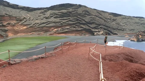 Young man visits El Charco Verde in El Golfo Stock Footage 136779771