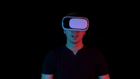 Young man in VR glasses. A man immersed in virtual reality makes movements with Stock Footage 123529409