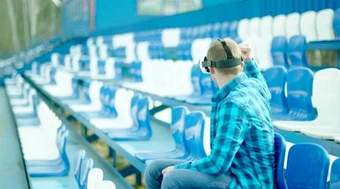 Young man in VR glasses rooting for a team on the tribune Stock Footage 63667743