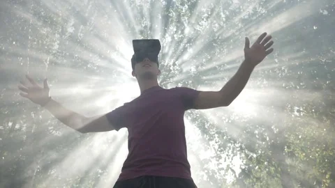 Young man with VR headset gadget immersed into virtual reality covered by lig Stock Footage 83114023