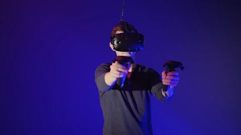 Young man in VR headset play interactive video game Stock Footage 99401513