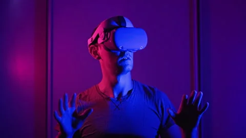 Young Man in VR Helmet Interacts with Virtual Reality Using His Hands Stock Footage 201250036