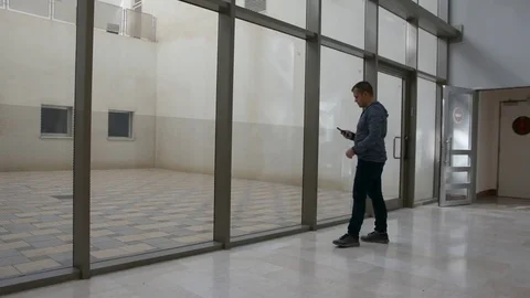 Young man waiting in hall with cellular Stock Footage 82191722
