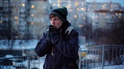 Young man waiting someone and having cold outside on winter Stock Footage 86332943