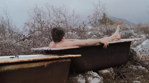 Young man wakes up and opens his eyes in an old bathroom Stock Footage 103809616