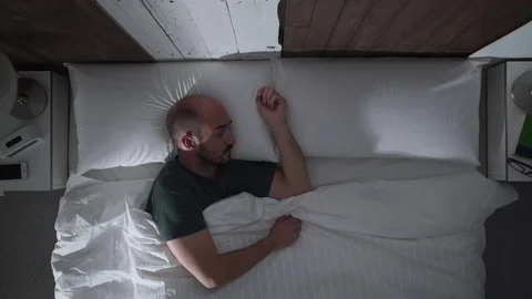 Young man wakes up at night Видео 71361539