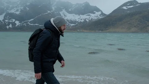 Young man walking alone on the beach on a winter day. strong wind Stock Footage 109379606