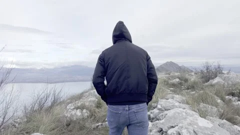 Young man walking along the mountain ridge Video stock 266435879